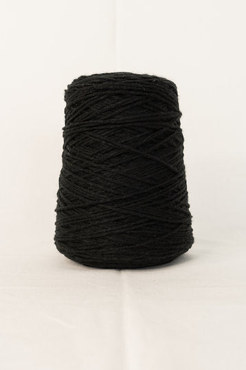 Cone of black tufting yarn on white background