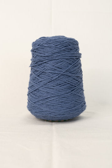 A cone of blue denim indigo acrylic yarn for tufting projects.