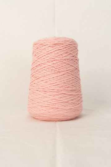 A cone of pink tufting yarn on a white background.