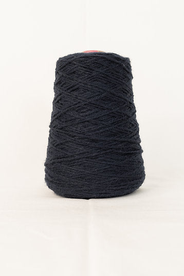 A cone of deep dark blue acrylic tufting yarn.