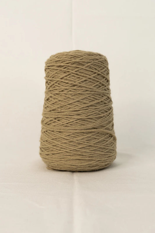 Cone of light brown tufting yarn on white background