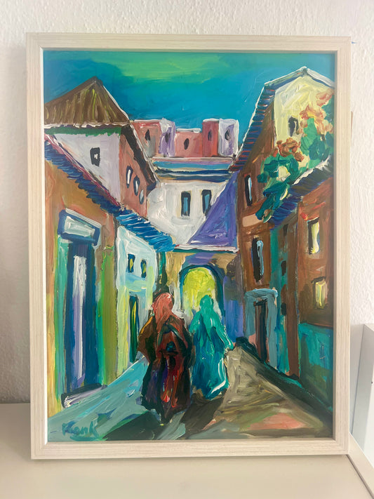 Framed acrylic painting of a colorful street scene with buildings and two people walking.