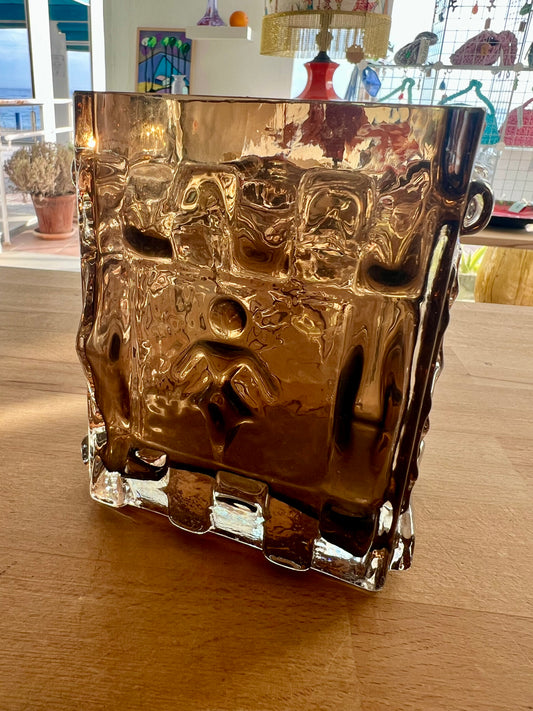 A smokey brown, square-shaped, heavy moulded glass vase with a silhouette design that embraces the female form.