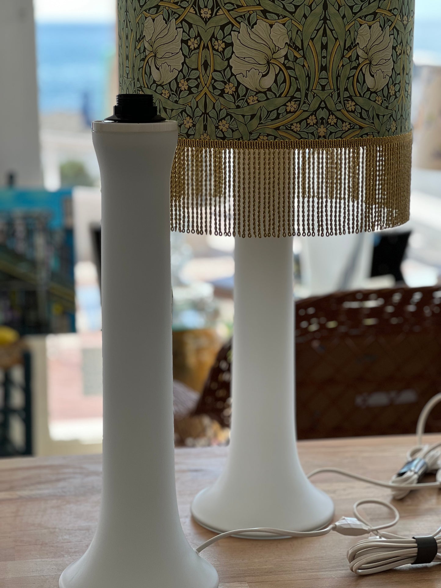 White glass lamp base columns with green floral lampshade with fringe