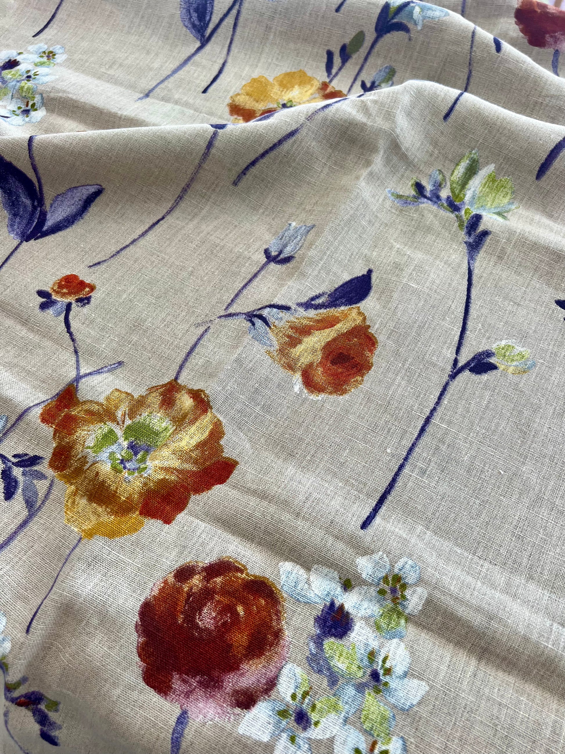 Floral fabric pattern with lavender, purple, and white flowers on a beige background