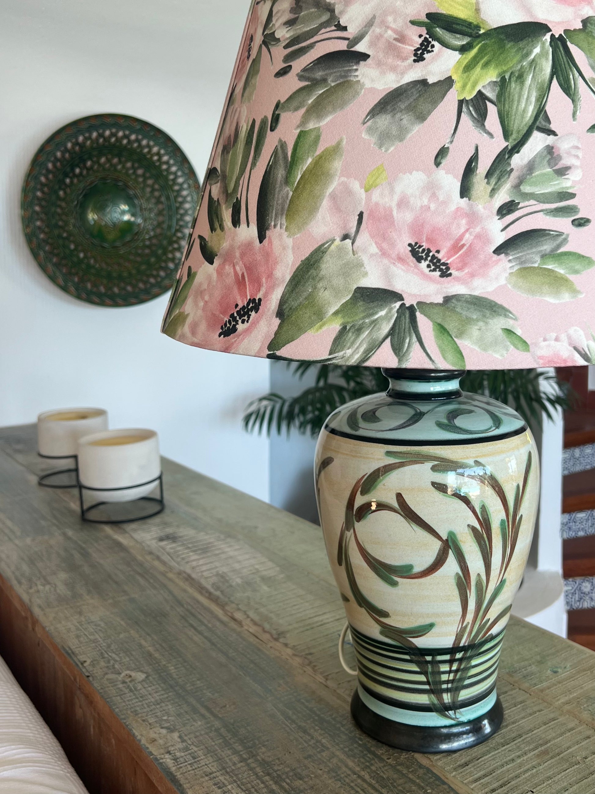 Green and cream motif on a Decorative ceramic lamp with pink floral pattern on the lampshade