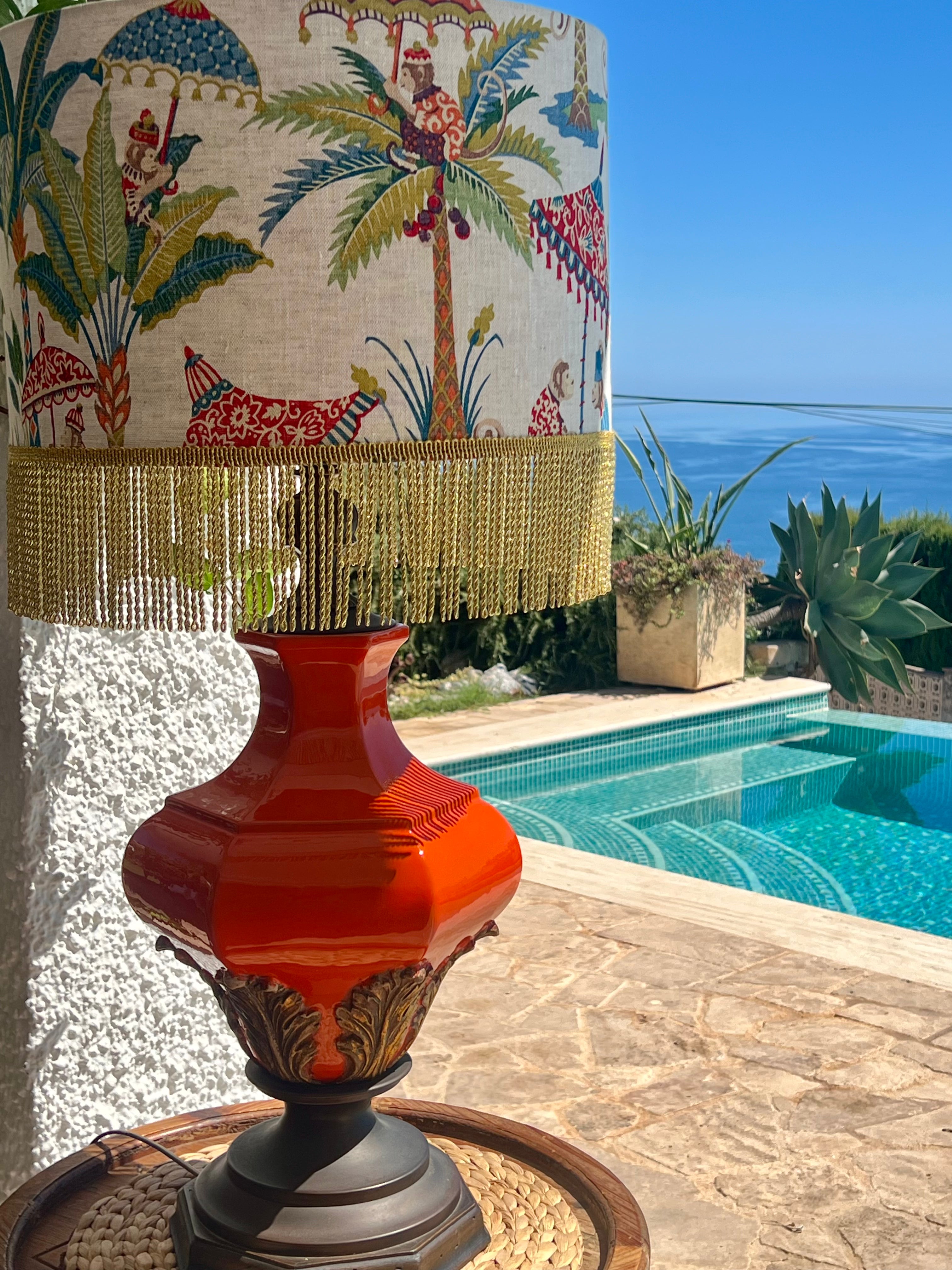 Decorative lamp with palm tree design against a poolside background