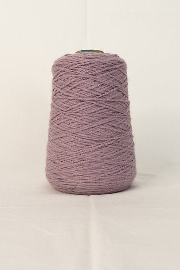 A cone of purple tufting yarn placed on a neutral background.