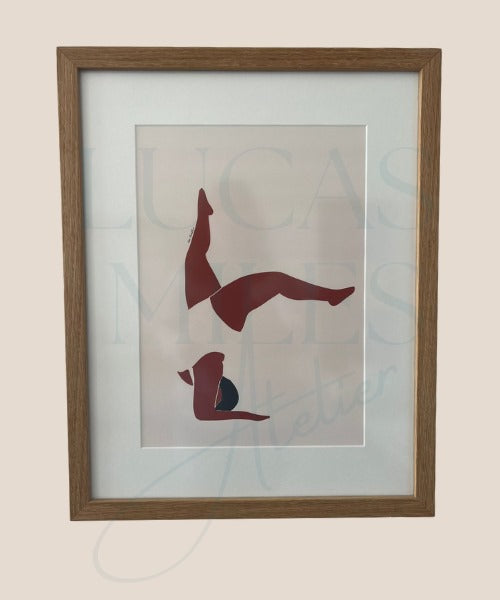 A framed digital print artwork featuring a rust and cream inversion design, representing the female form, placed within a light wooden frame.