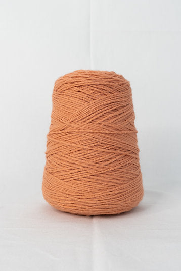 A cone of tangerine acrylic yarn for tufting projects, placed on a white background.