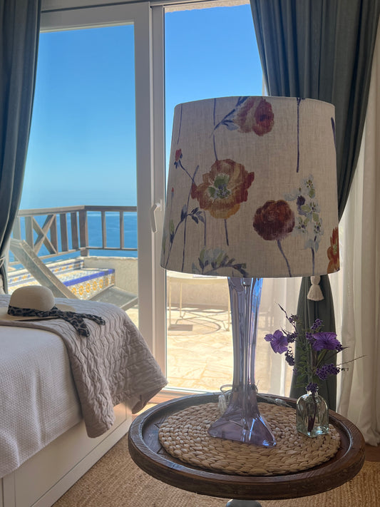 Decorative lamp with floral shade in a room with ocean view