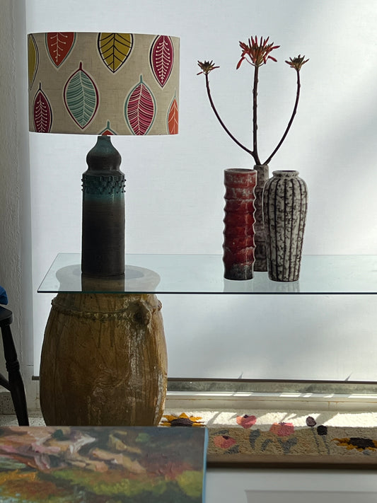 Leaf motif lampshade on ceramic lamp base with vases