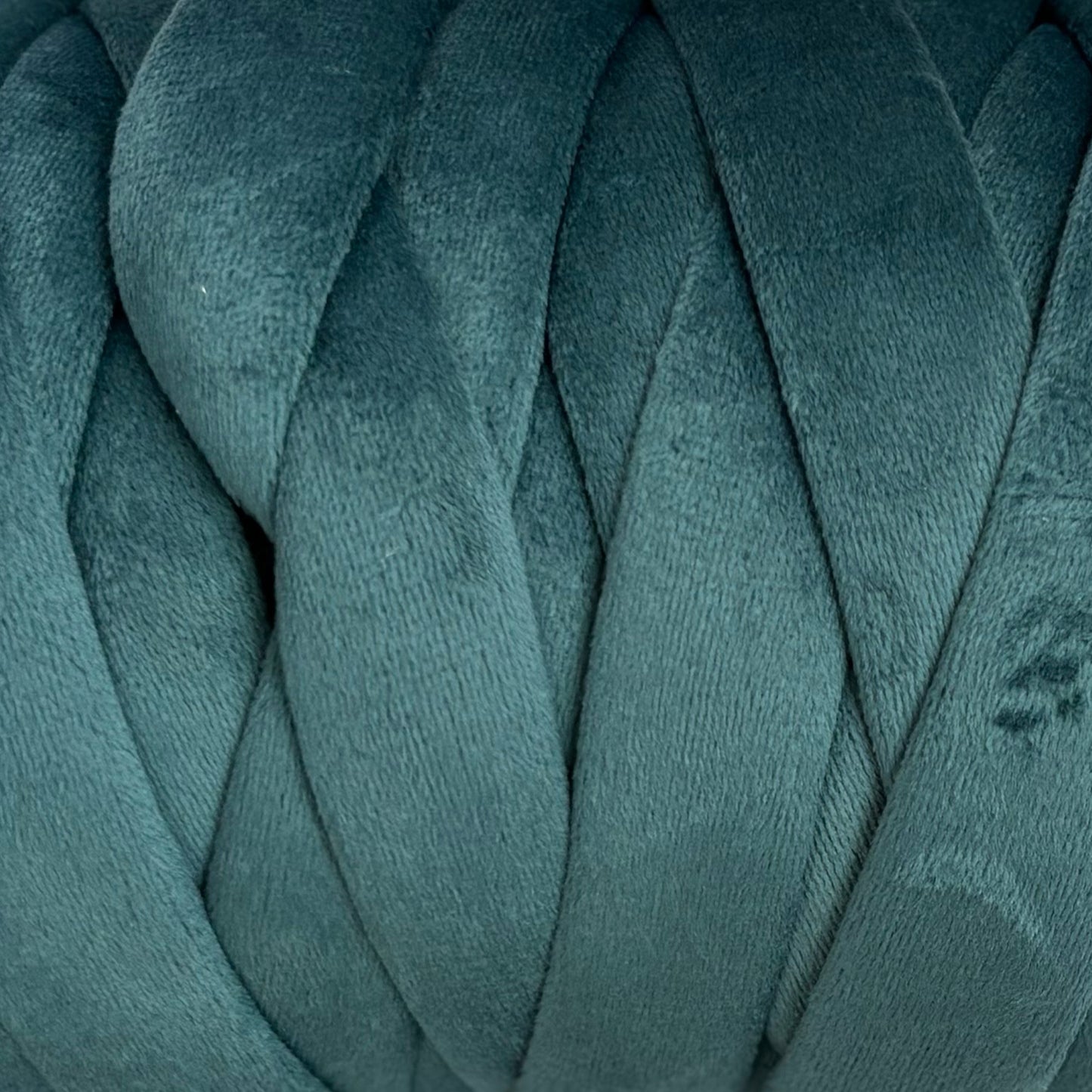 Close-up of teal velvet yarn with a textured pattern