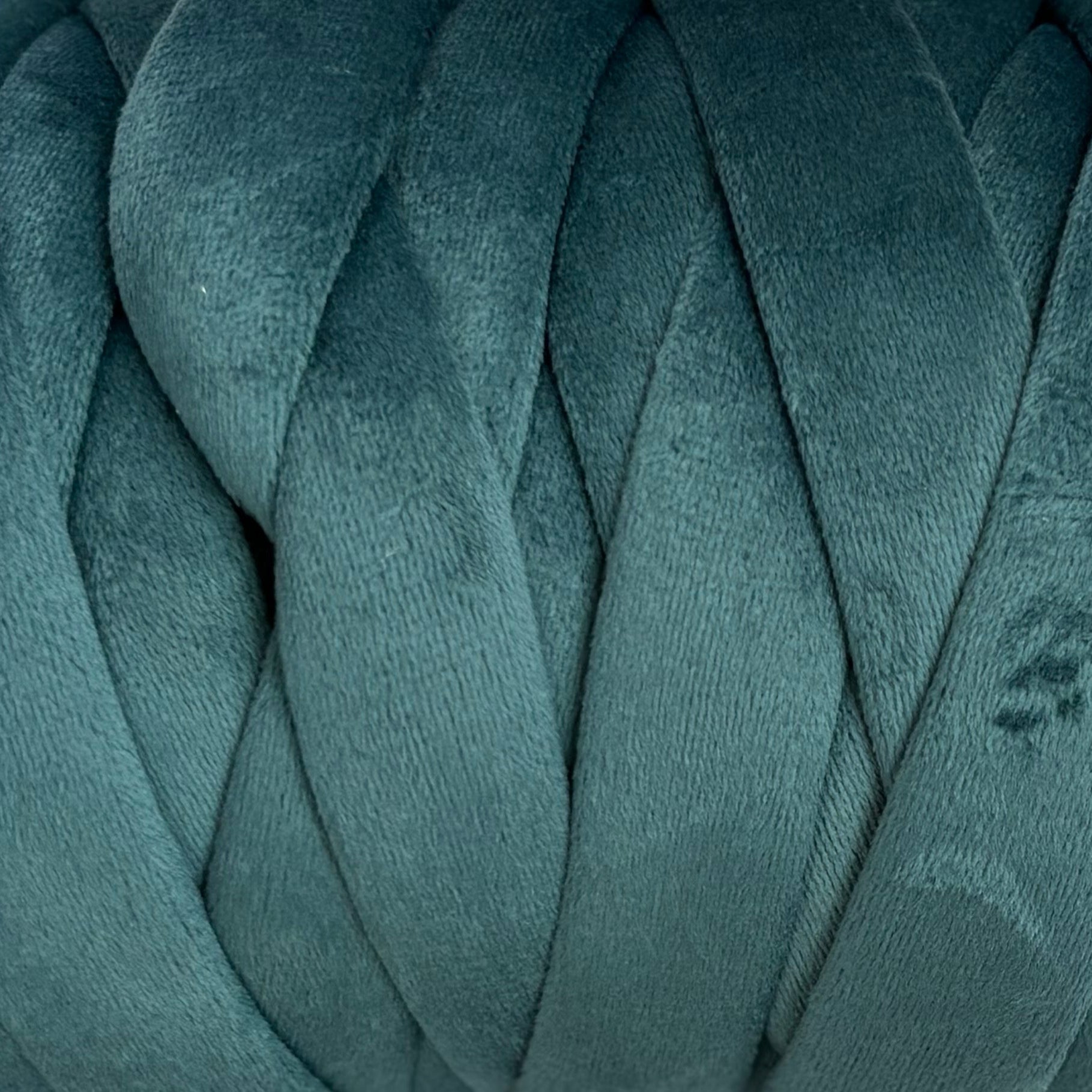 Close-up of teal velvet yarn with a textured pattern